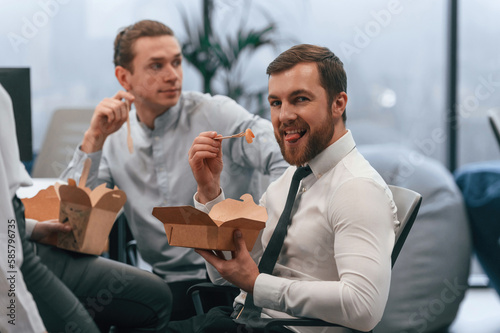 Fototapeta Naklejka Na Ścianę i Meble -  Coworkers are sitting in the office and eating food from eco boxes