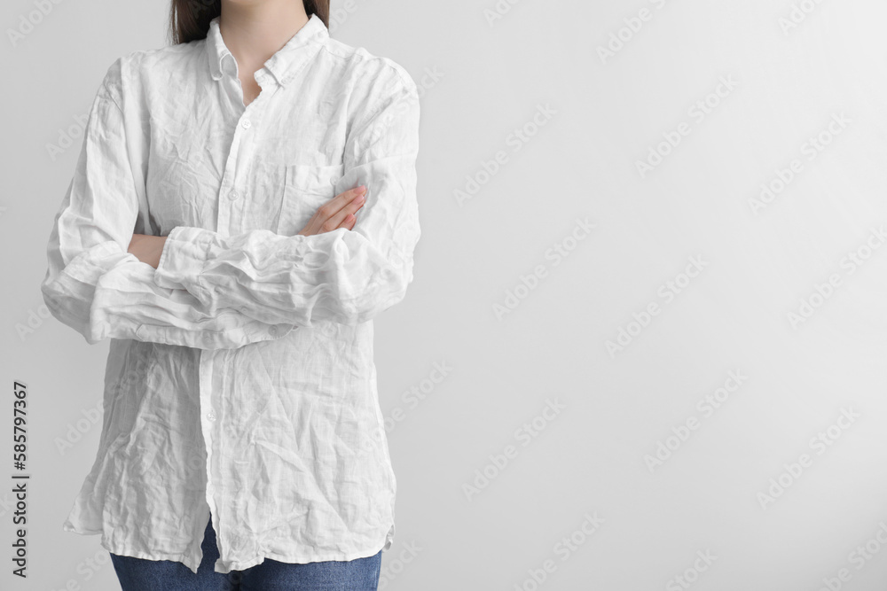 Woman wearing wrinkled white blouse on light grey background, closeup. Space for text Woman wearing wrinkled white blouse on light grey background, closeup. Space for text