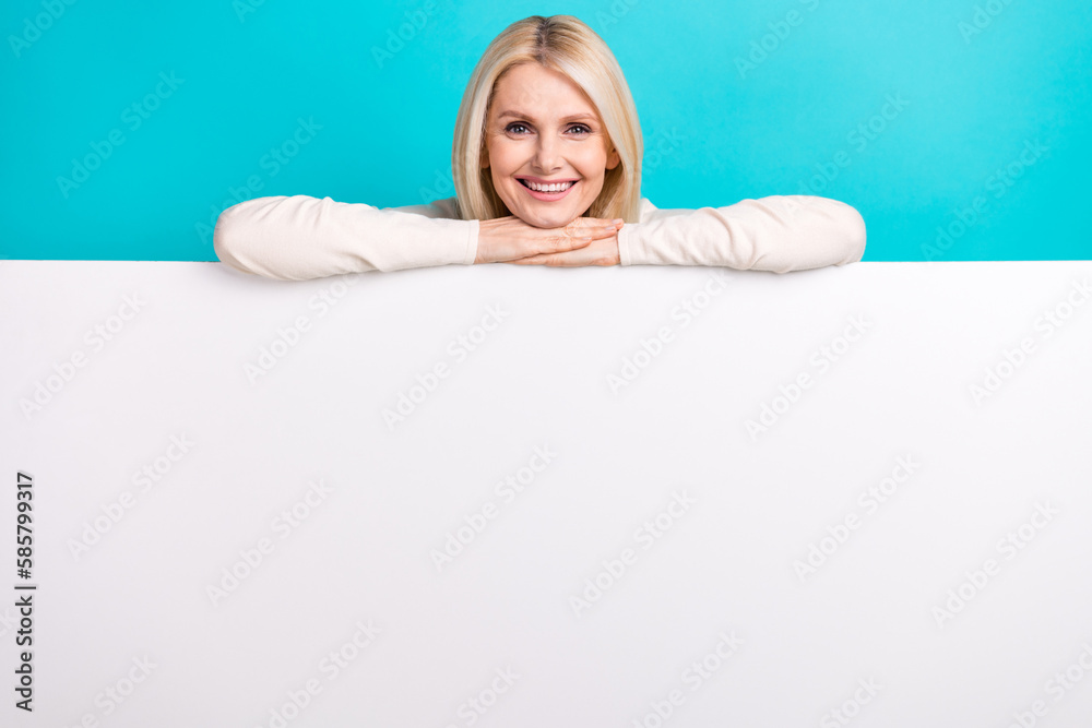 Photo of cute adorable woman wear white shirt holding poster empty space isolated turquoise color background Photo of cute adorable woman wear white shirt holding poster empty space isolated turquoise color background