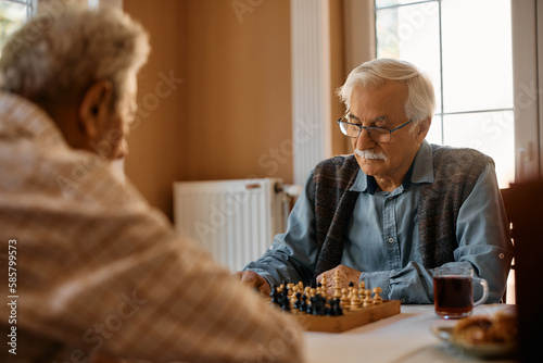 Senior man plays chess with his friend in residential care home. photo