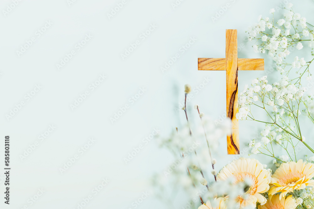 Wooden cross with spring flowers on blue background with copy space. Religion background. Religious church holidays. Christianity Feast, Easter, Palm Sunday, Christening, church wedding. Flat lay - obrazy, fototapety, plakaty 