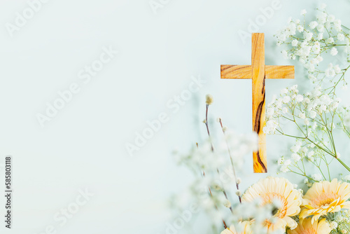 Fotografiet Wooden cross with spring flowers on blue background with copy space
