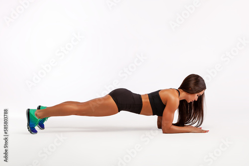 Plank on the elbows. A young woman performs an athletic exercise. Fitness woman doing an elbow plank