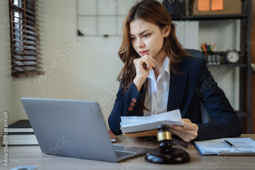 Lawyer woman working with paperwork on his desk in office workplace for consultant lawyer in office.