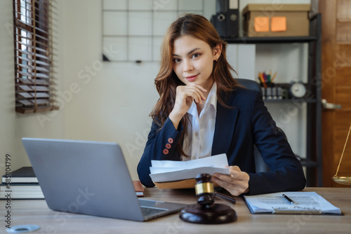 Female asian sitting at the desk, looking to camera. © NINENII