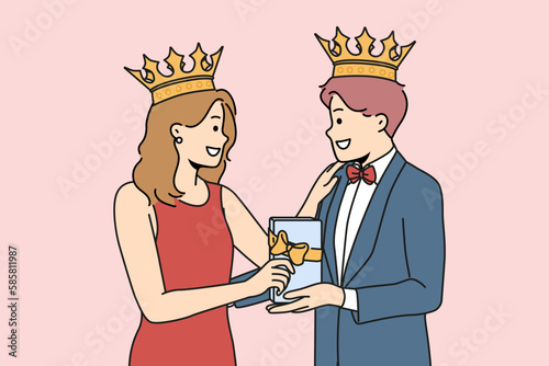 Smiling couple in formalwear with gift box in hands. Happy man and woman with crowns on heads celebrate anniversary holding present. Vector illustration. 