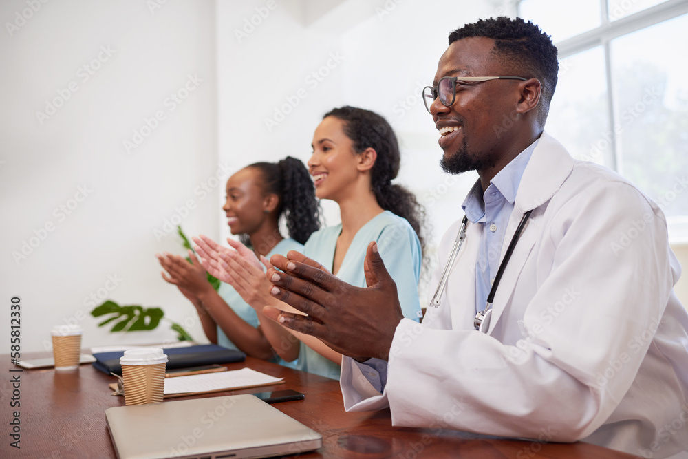 Three doctors in a row, clapping at medical presentation in hospital boardroom Three doctors in a row, clapping at medical presentation in hospital boardroom