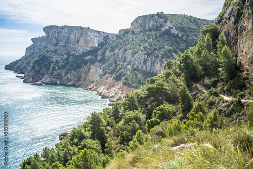 Moraig pebble beach. cliffs, rocks, mountain path and view of the mediterranean sea on a beautiful sunny day
 photo