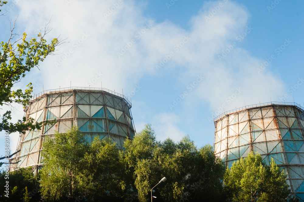 Cooling towers at power plants emit puffs of steam into the atmosphere. Pipes Heat power station against the background of the sky Cooling towers at power plants emit puffs of steam into the atmosphere. Pipes Heat power station against the background of the sky