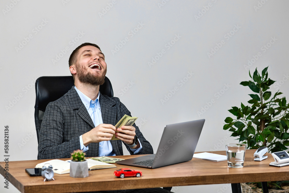 young bearded businessman working on laptop and holding money young bearded businessman working on laptop and holding money