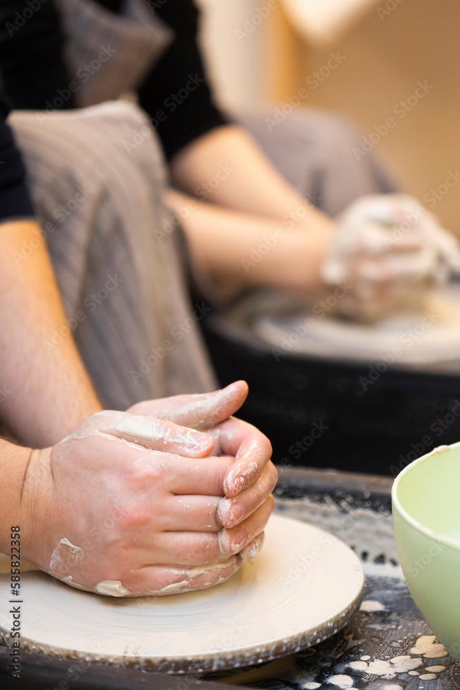 Hands of man who has just made pottery or ceramic on potter's wheel   