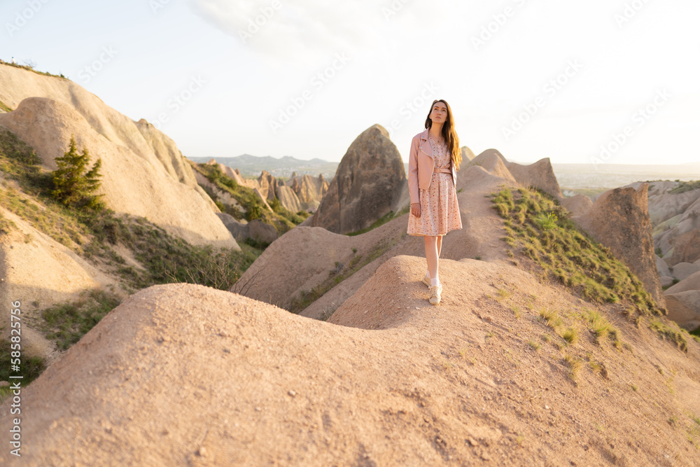 a beautiful girl walks on the top of the mountain enjoying the view.