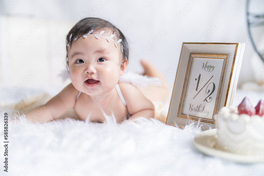 明るい自然光でハーフバースデーをお祝いする生後6か月の天使の赤ちゃん - obrazy, fototapety, plakaty 