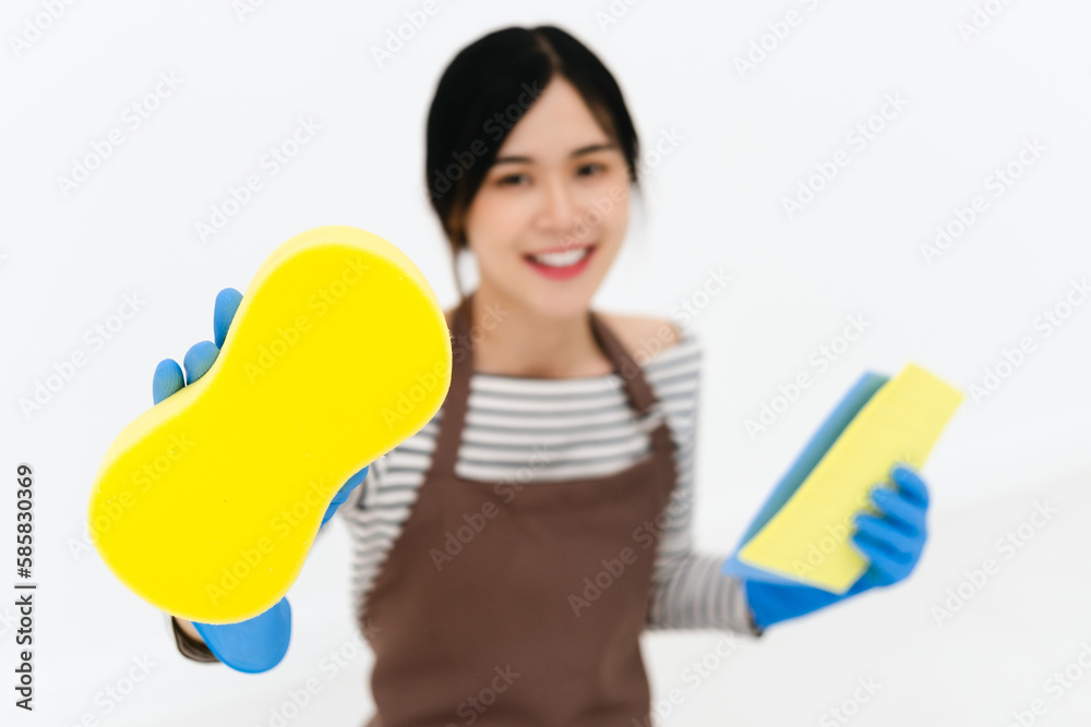 Happy young woman wearing blue rubber gloves for hands protection , holding sponge , smiling at camera while cleaning house isolated over white background Happy young woman wearing blue rubber gloves for hands protection , holding sponge , smiling at camera while cleaning house isolated over white background