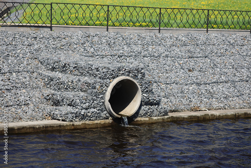 Water outflows in the river through flood drainage system.