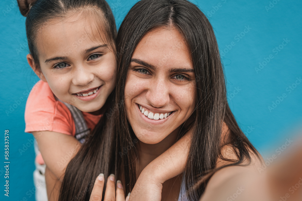 Happy teenage girl taking a selfie with her little sister outdoor - Youth culture concept Happy teenage girl taking a selfie with her little sister outdoor - Youth culture concept