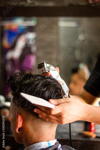 Latin barber shop, man with short hairstyle, close-up on the head.