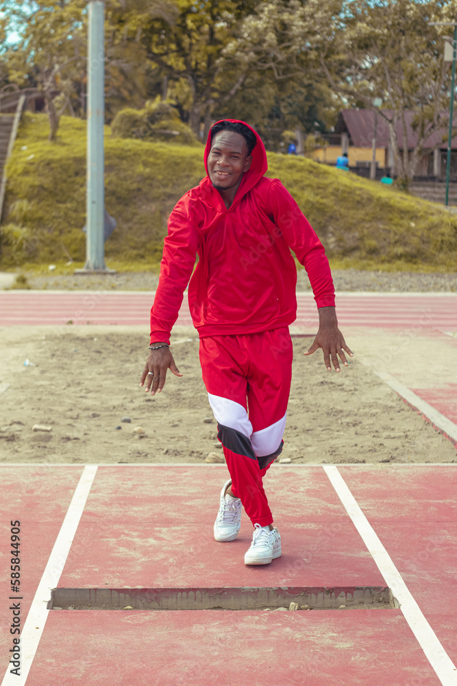 Obraz premium Joven afro bailando al estilo urbano en un parque, con hermosa vegetacion y cielo de fondo