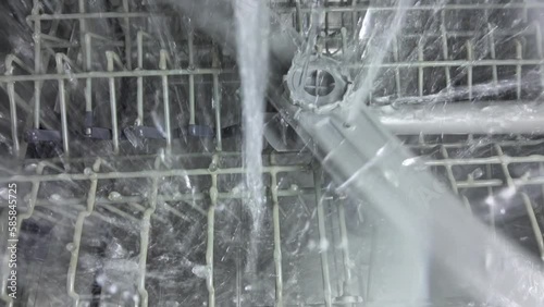 Inside the dishwasher. The process of washing dishes. The nozzle mechanism rotates.