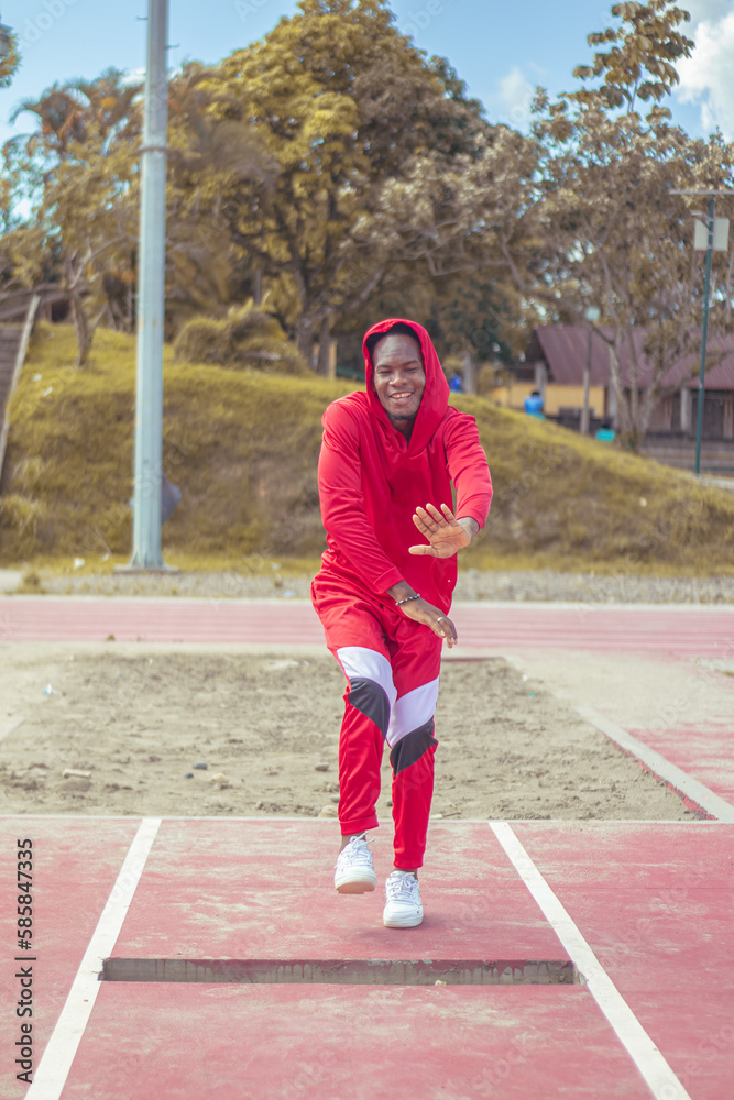 Joven afro bailando al estilo urbano en un parque, con hermosa vegetacion y cielo de fondo Joven afro bailando al estilo urbano en un parque, con hermosa vegetacion y cielo de fondo