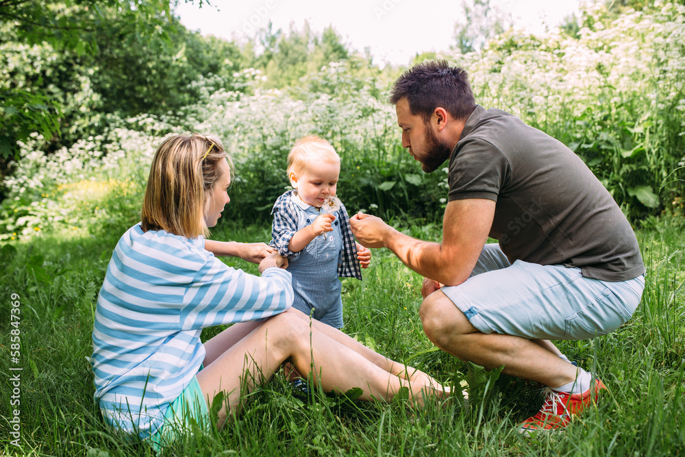 Mom, dad and little son spend time together in the summer outdoors Mom, dad and little son spend time together in the summer outdoors