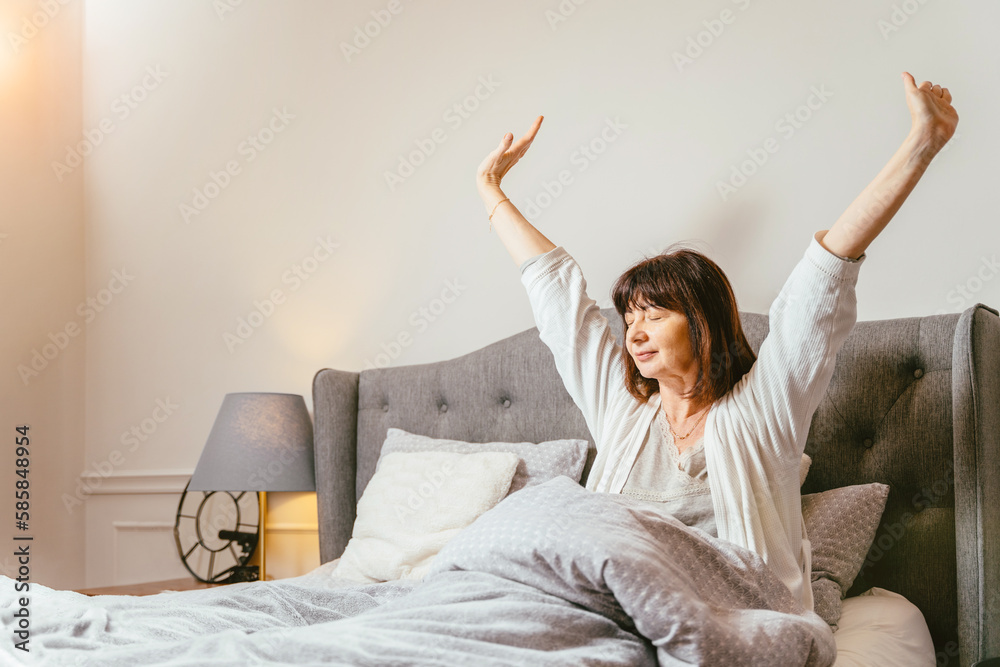 Happy fresh mature middle aged woman stretching in bed waking up alone happy concept, feel hope and relax, alone at home. Happy fresh mature middle aged woman stretching in bed waking up alone happy concept, feel hope and relax, alone at home.