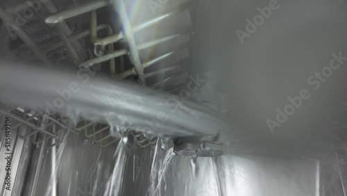 Inside the dishwasher. The process of washing dishes. The nozzle mechanism rotates.