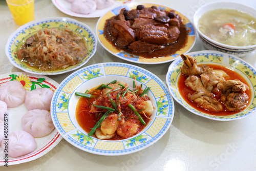 Home cooked taro braised pork, curry chicken, sweet and sour fish, stir fry yam bean and white pepper pig stomach soup. Traditional Malaysian Chinese food eating during Chinese festival.