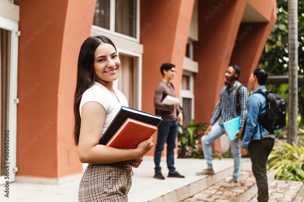 Fototapeta premium Laughing latin american female student with group of young adults.