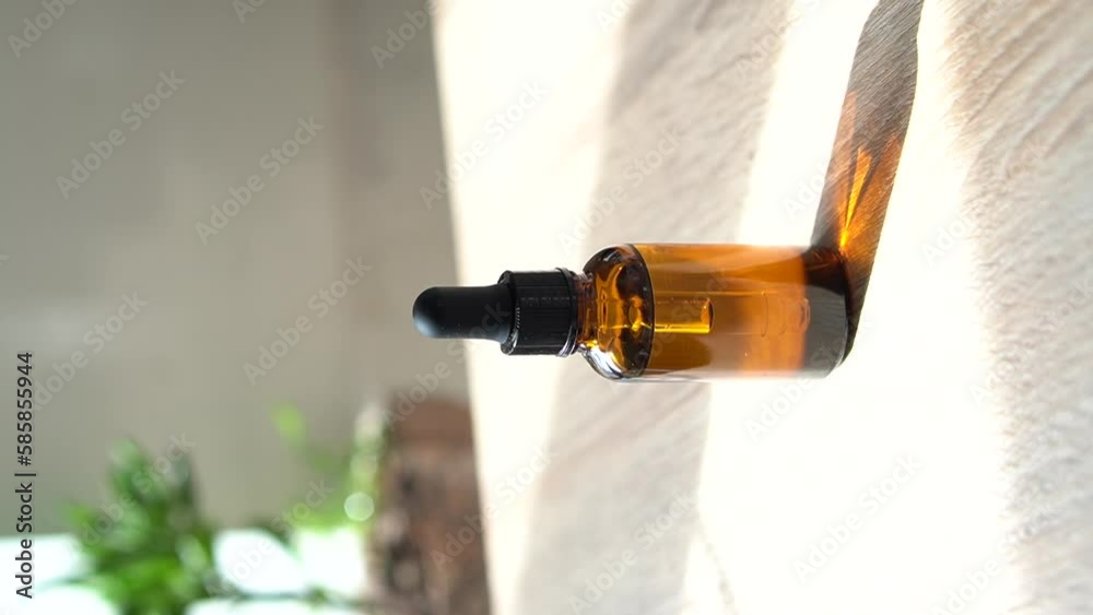 Brown amber glass serum oil dropper bottle and white towel on table mock-up, vertical shot of cosmetic container in real interior Brown amber glass serum oil dropper bottle and white towel on table mock-up, vertical shot of cosmetic container in real interior