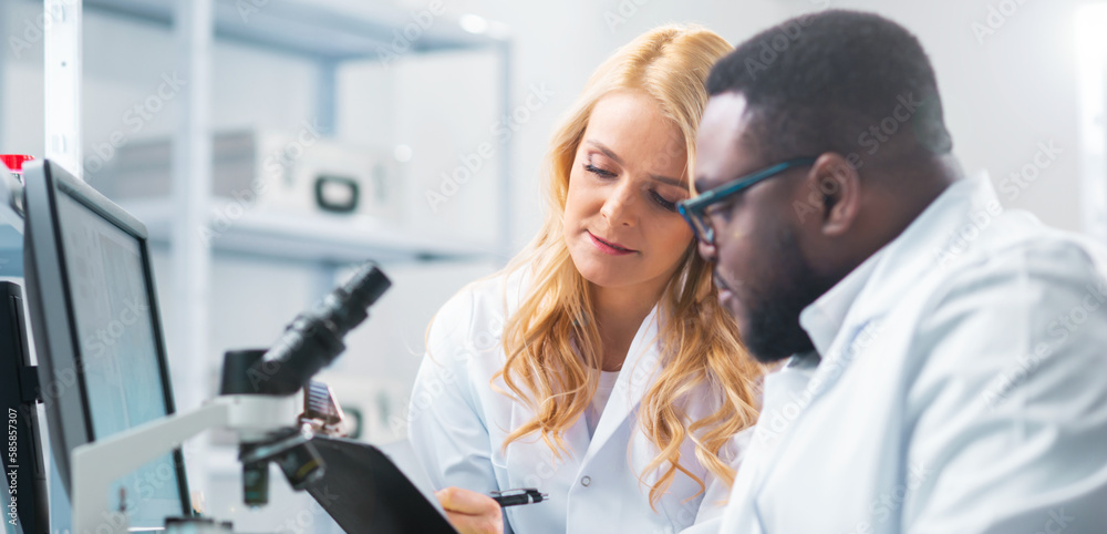 Team of professional scientists working on a vaccine in a modern scientific research laboratory. Genetic engineer workplace. Future technology, healthcare and science. Team of professional scientists working on a vaccine in a modern scientific research laboratory. Genetic engineer workplace. Future technology, healthcare and science.
