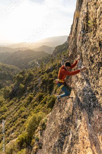 man climbing at sunset in the mountains with the forest in the background, copy space, business, security, trust