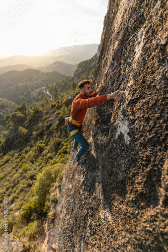 man climbing at sunset in the mountains with the forest in the background, copy space, business, security, trust