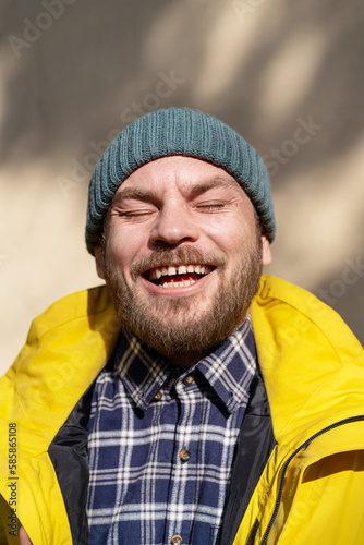 Fotografie Portrait quirky adult man enjoying spring sun candid smiling with eyes closed