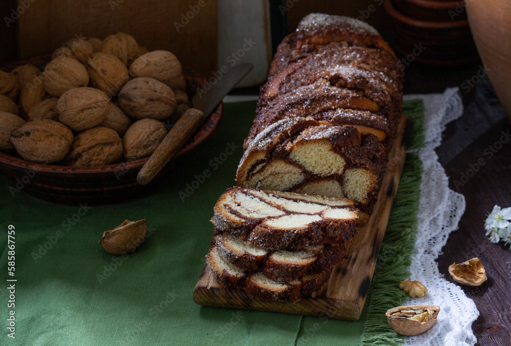 Traditional Easter bread with chocolate and nut filling on a wooden background.