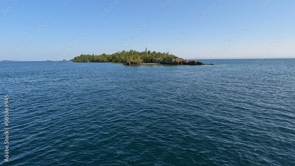 Gliding through the pure waters of Lake Superior with views of tiny island covered in pine trees. Gliding through the pure waters of Lake Superior with views of tiny island covered in pine trees.