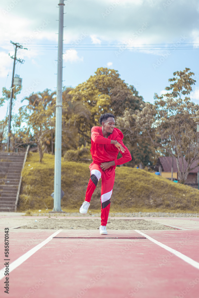 Joven afro bailando al estilo urbano en un parque, con hermosa vegetacion y cielo de fondo Joven afro bailando al estilo urbano en un parque, con hermosa vegetacion y cielo de fondo