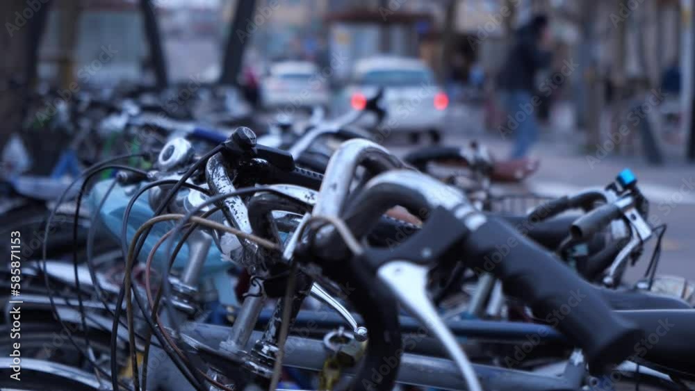 bicycles parked in parking lot with blurred background of cars and unrecognizable walking people, sustainable mobility transportation video bicycles parked in parking lot with blurred background of cars and unrecognizable walking people, sustainable mobility transportation video