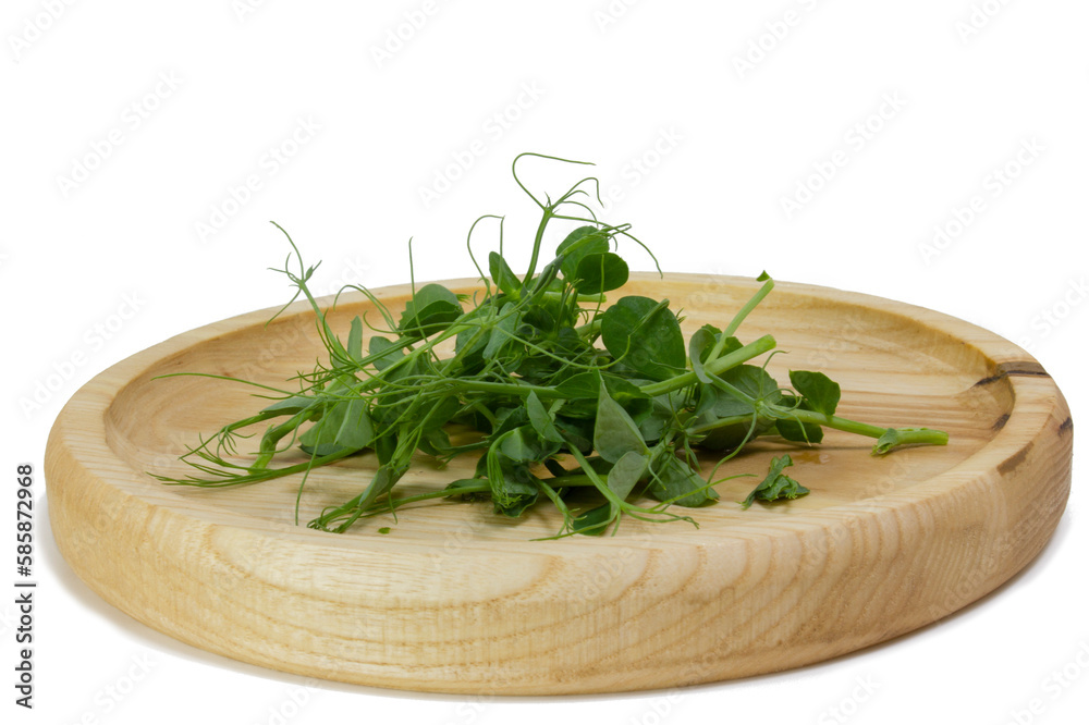 Pea sprouts microgreens in a wooden bowl. Green shoots of yak, young plants, sprouts of a tasty and useful plant. Macro photo of food close-up on white background, side view Pea sprouts microgreens in a wooden bowl. Green shoots of yak, young plants, sprouts of a tasty and useful plant. Macro photo of food close-up on white background, side view