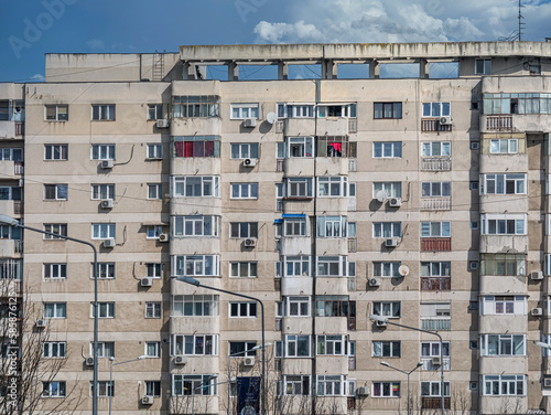Worn out apartment building from the communist era against blue sky in Bucharest Romania. Ugly traditional communist housing ensemble © Cristi