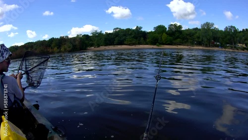 Wide angle headcount view while catching sturgeon from kayak while fishing on the river. photo