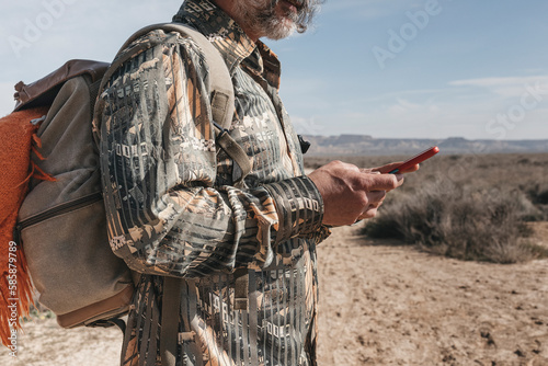 Middle-aged man using her smartphone on a day hike