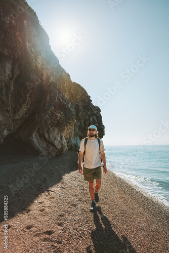 Man traveler walking on empty beach travel lifestyle active summer vacations outdoor sea view