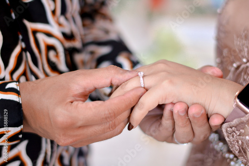 bride and groom holding hands and exchanging rings
