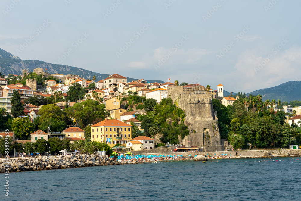 View of city Herceg Novi and fortress from sea. Coastal town in Montenegro located at entrance to Bay of Kotor and at foot of Mount Orjen. Adriatic Sea