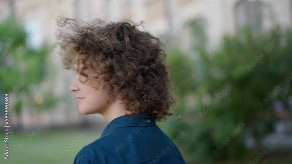 Caucasian cute boy with curly hair looking around in slow motion standing outdoors. Portrait of charming kid enjoying weekend leisure. Childhood and lifestyle concept Caucasian cute boy with curly hair looking around in slow motion standing outdoors. Portrait of charming kid enjoying weekend leisure. Childhood and lifestyle concept