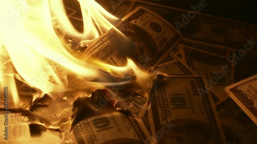 Heap of burning US dollars turning into ashes close up, symbolizing the destruction of wealth and the financial crisis. Conceptual footage for an economic downturn and money loss photo