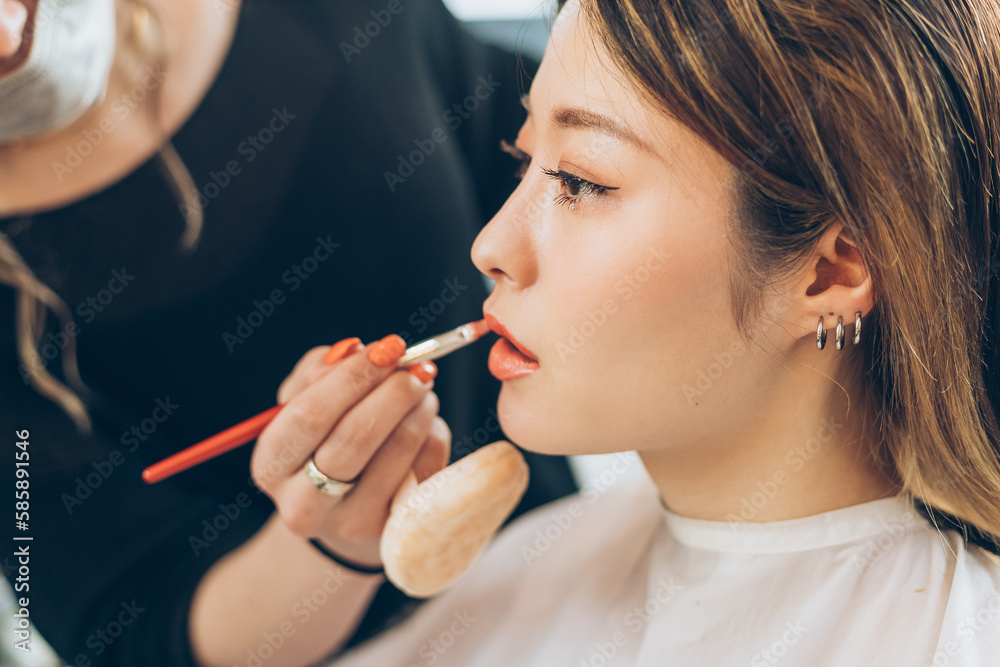 Obraz premium 美容室でリップメイクをする女性
