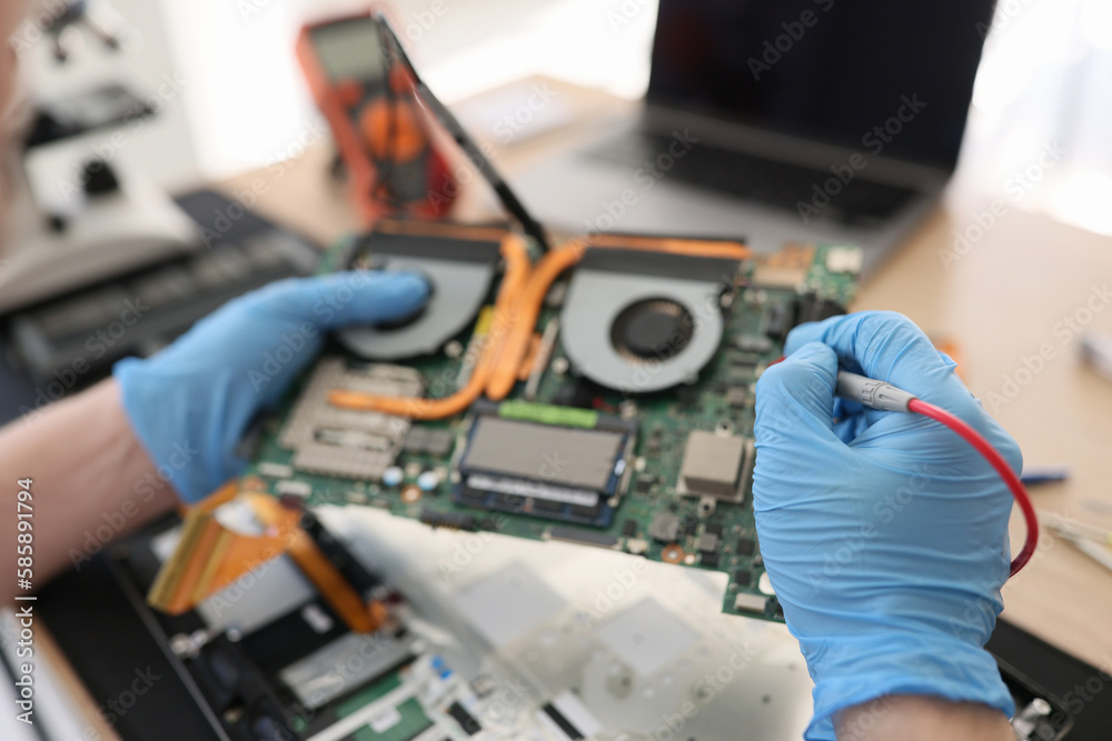 Repairman in gloves checkups computer motherboard in shop Repairman in gloves checkups computer motherboard in shop