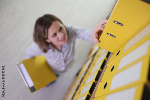 Employee looks for ring binder with accounting materials photo